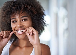 young woman smiling while flossing 