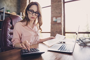 woman calculating cost of cosmetic dentistry in Castle Shannon