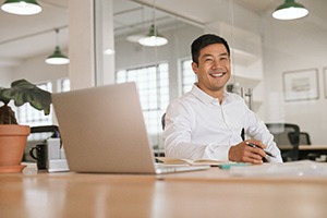 person sitting at their desk and smiling