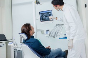 Dentist and patient looking at digital x-rays