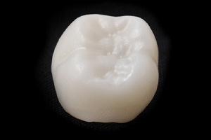 White ceramic dental crown on a black background