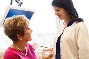 Older woman holding denture