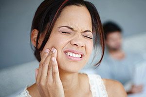 Woman in pain holding jaw