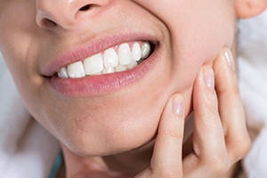 Closeup of patient holding jaw in pain